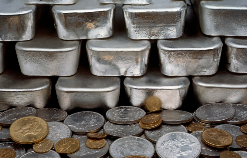 Silver bars with various gold and silver coins around them